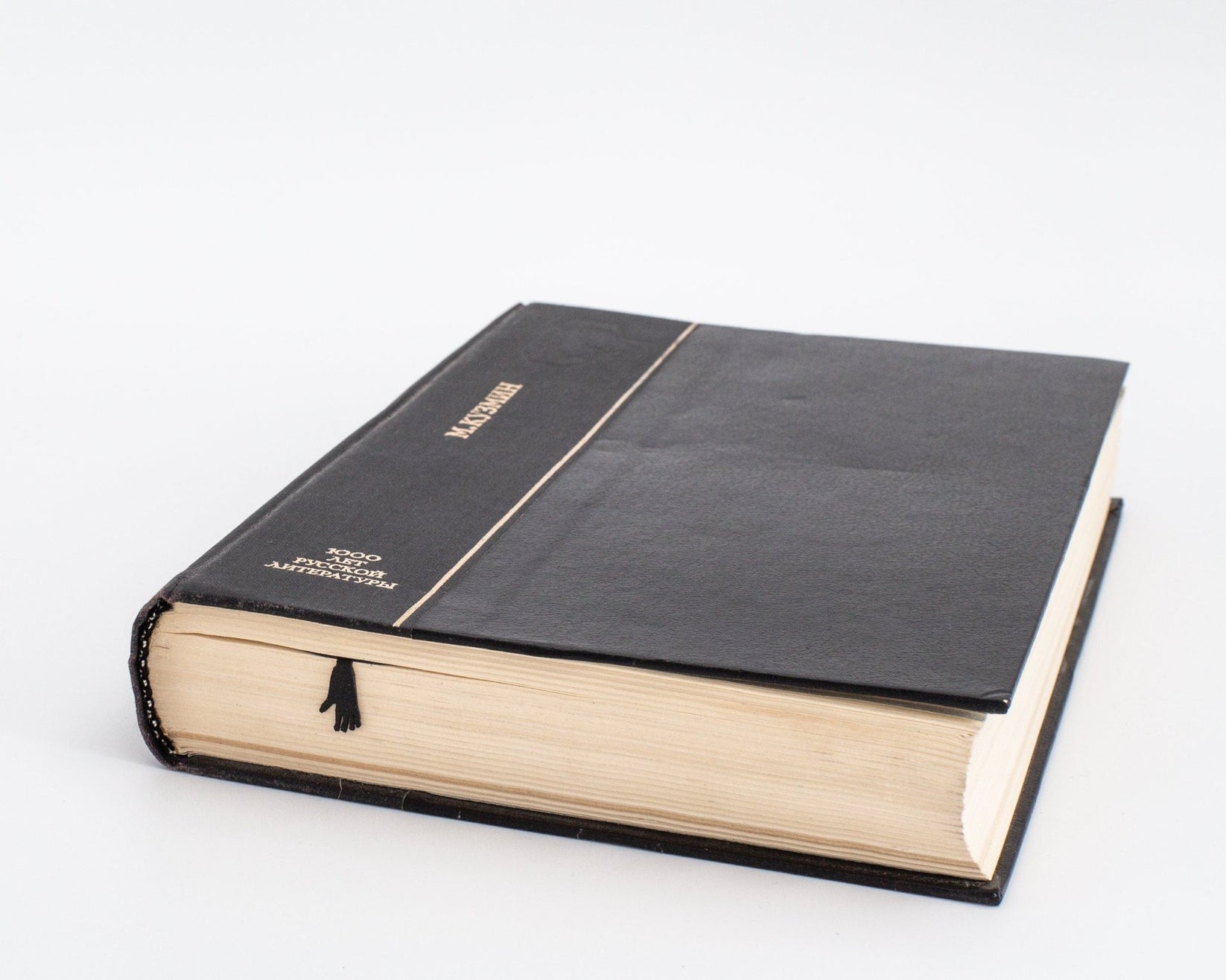 Chimp metal bookmark in a closed book, only its top showing above the pages