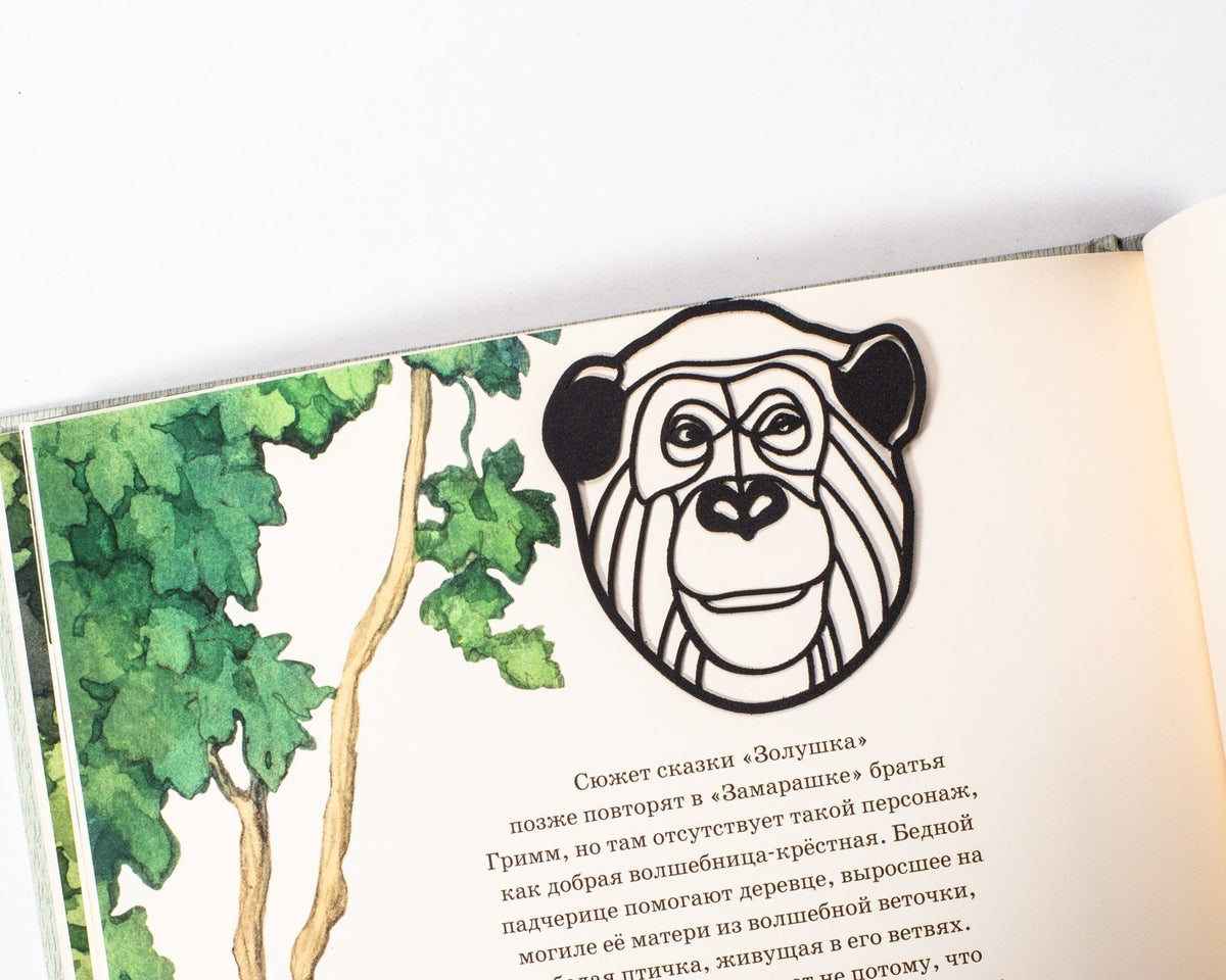 Chimp metal bookmark marking a page in an illustrated book