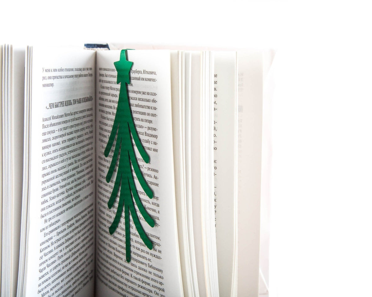 Christmas Tree metal bookmark in green set into the gutter of an open book