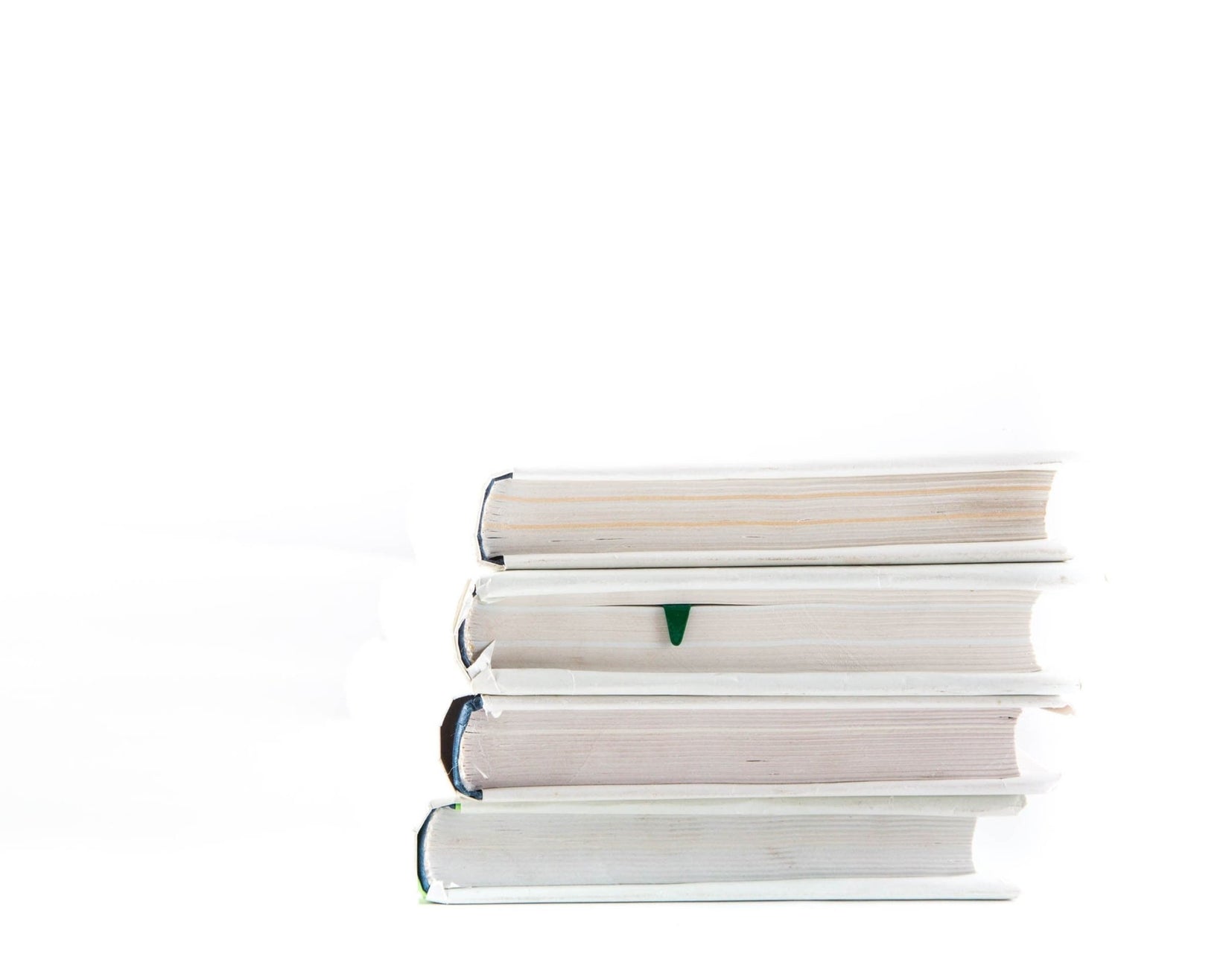 Christmas Tree metal bookmark in green shown with a stack of books
