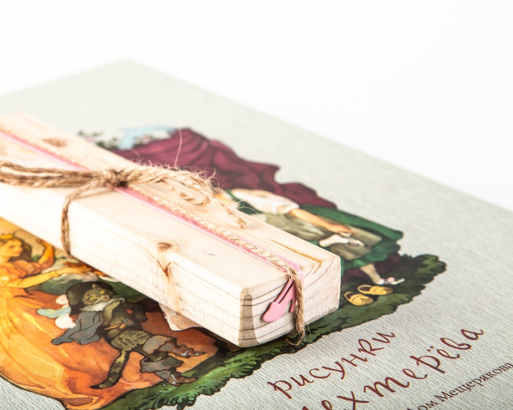 Cinderella's Slipper metal bookmark in red placed on a colour illustration