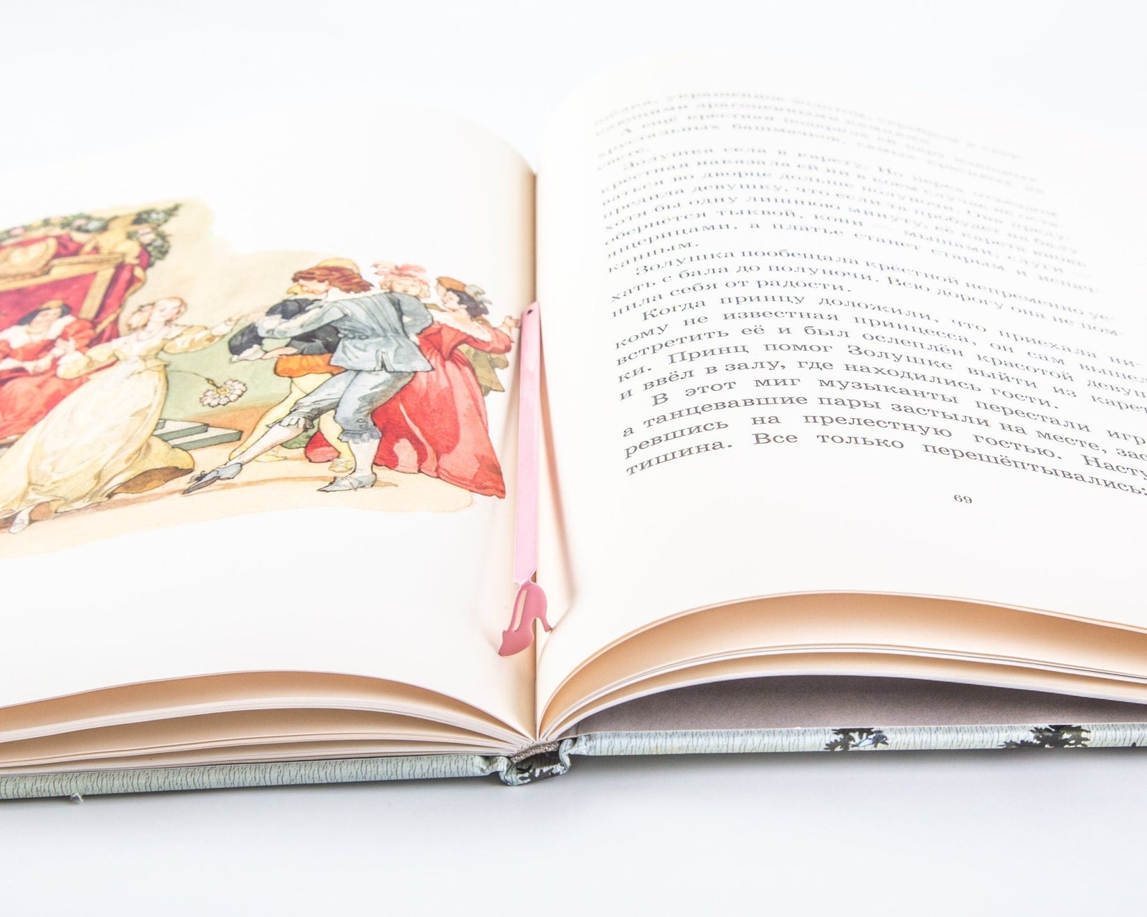 Cinderella's Slipper metal bookmark in red resting on the pages of an open book