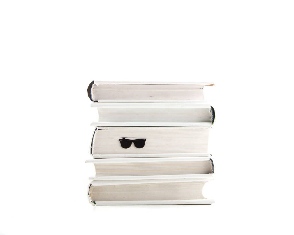 Cool Sunglasses metal bookmark shown with a stack of books