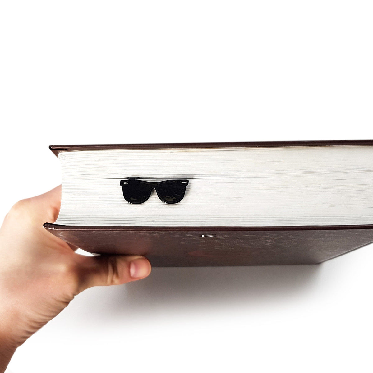 Cool Sunglasses metal bookmark in a closed book, only its top showing above the pages