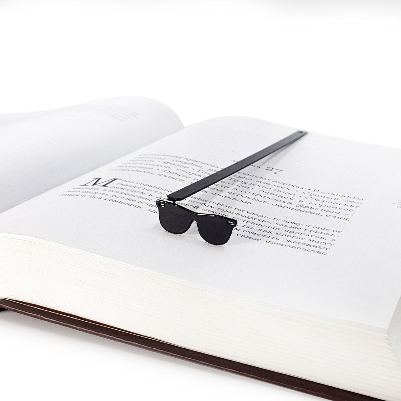 Cool Sunglasses metal bookmark resting on the pages of an open book