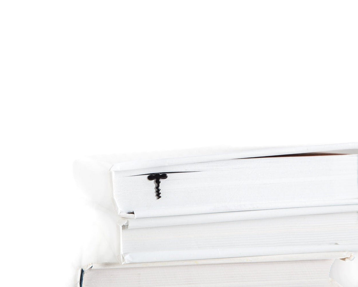 Corkscrew metal bookmark in a closed book, only its top showing above the pages