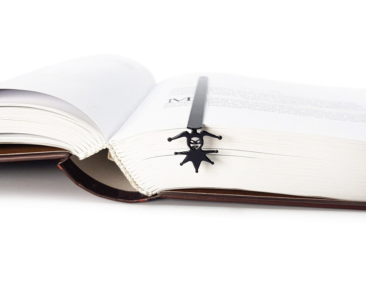 Court Jester metal bookmark clipped in a closed book, viewed from the side