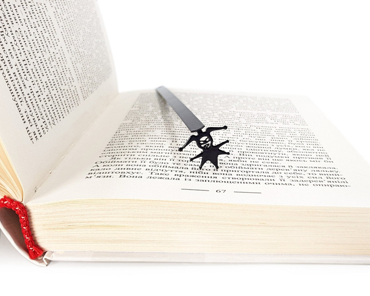 Court Jester metal bookmark in a closed book, only its top showing above the pages