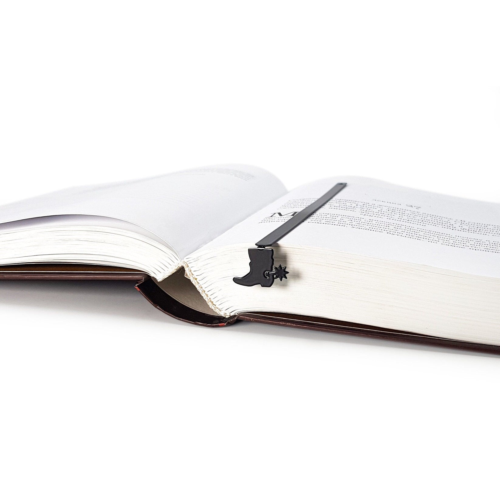 Cowboy's Boot metal bookmark lying across the pages of an open book