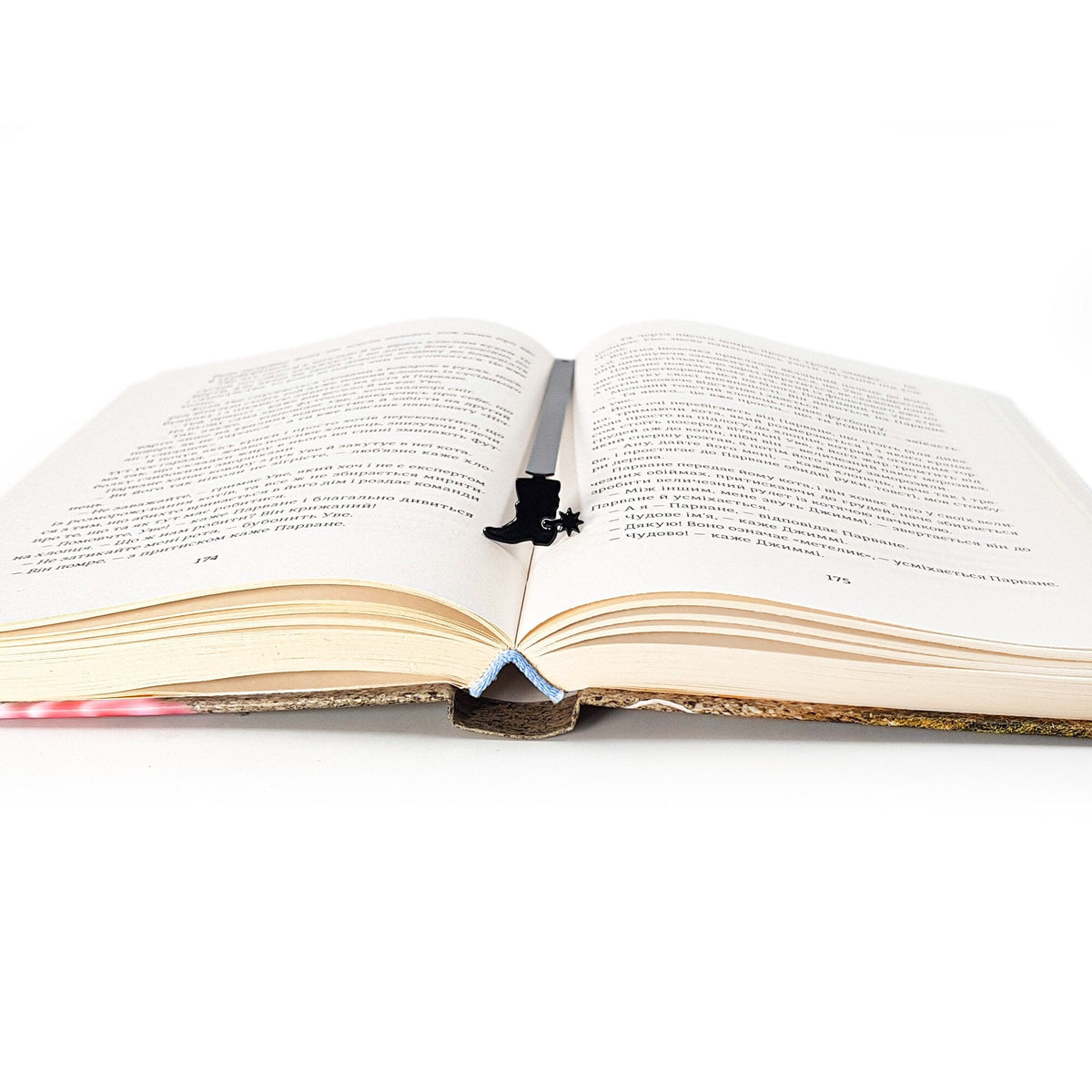 Cowboy's Boot metal bookmark marking a page in an open book
