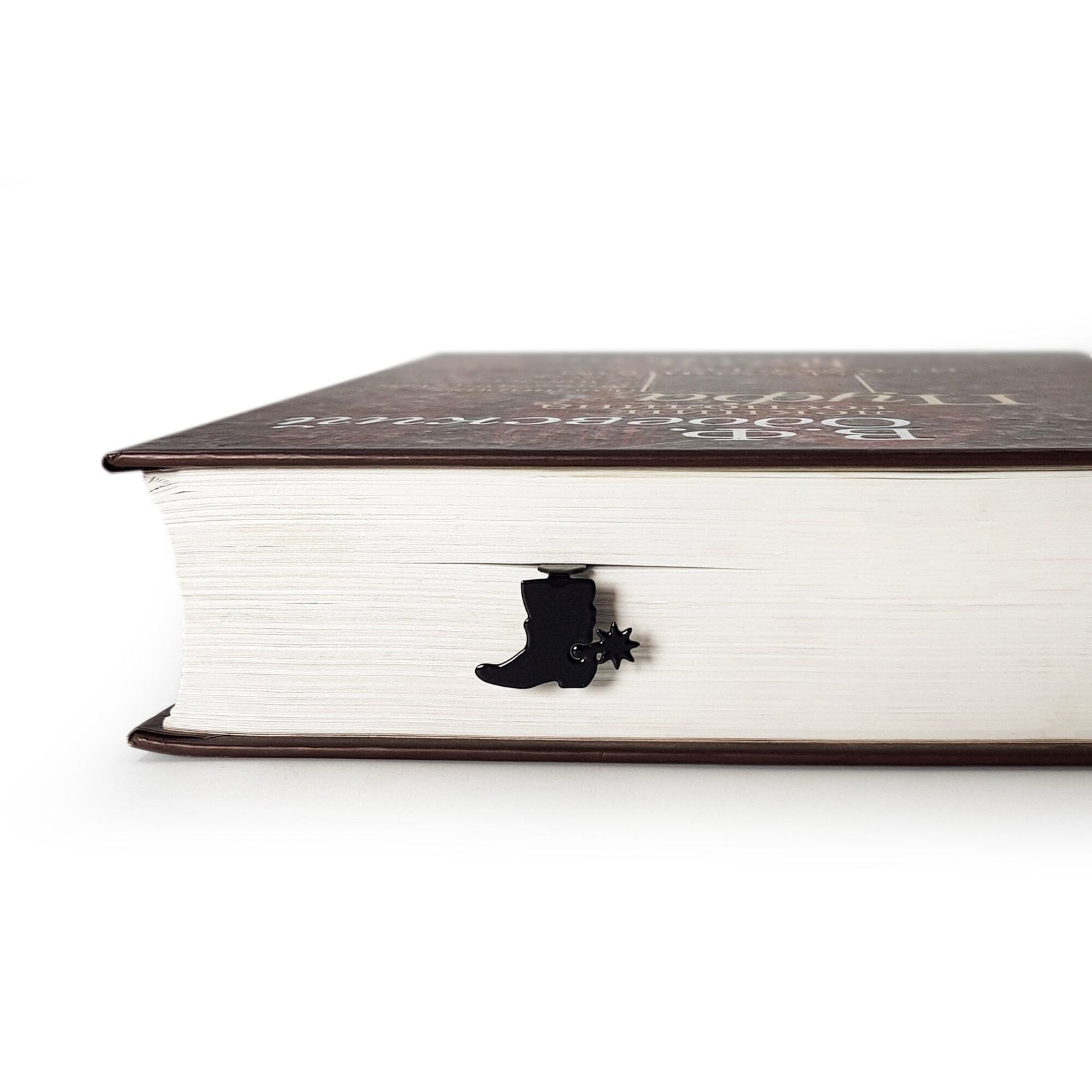 Cowboy's Boot metal bookmark in a closed book, only its top showing above the pages