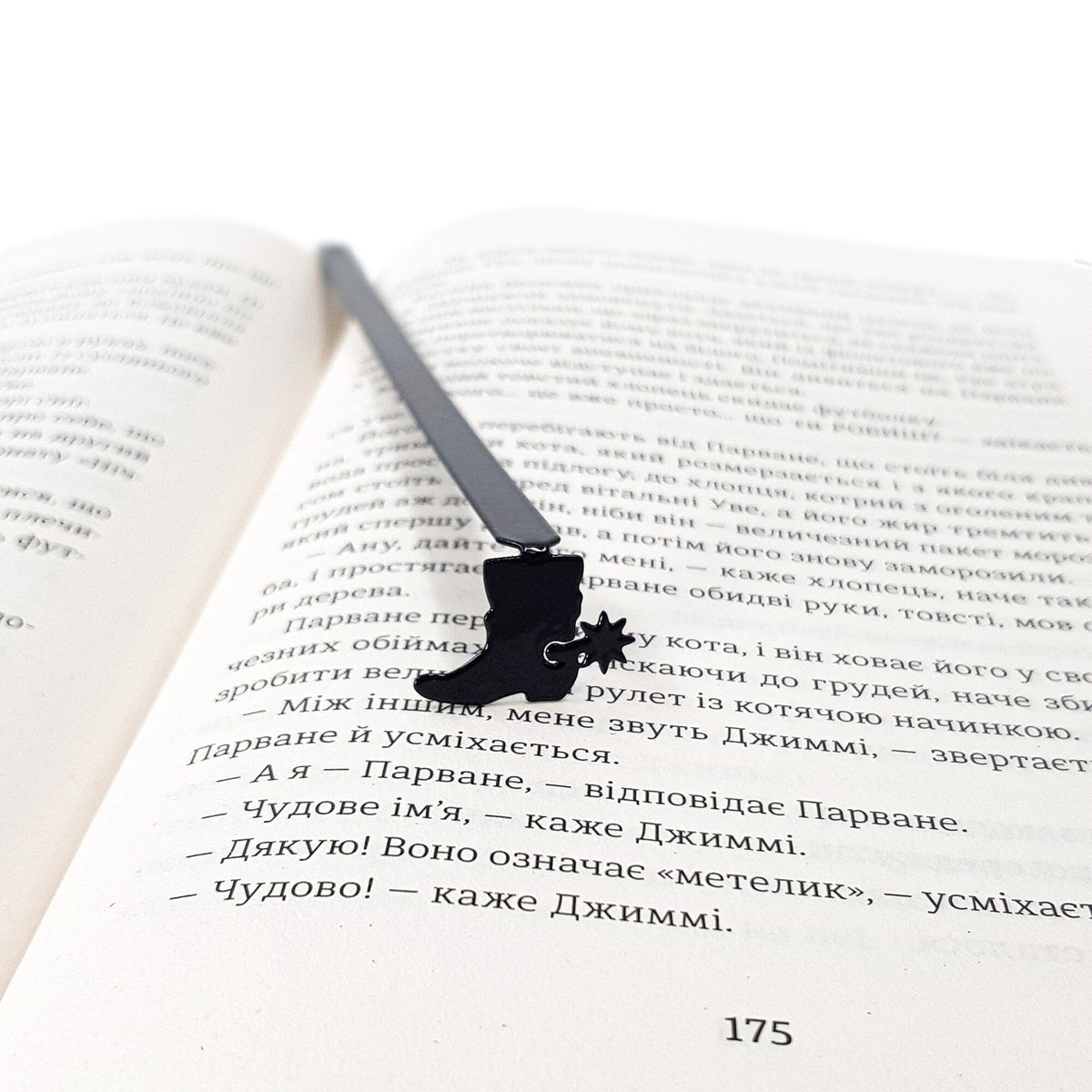 Cowboy's Boot metal bookmark resting on the pages of an open book