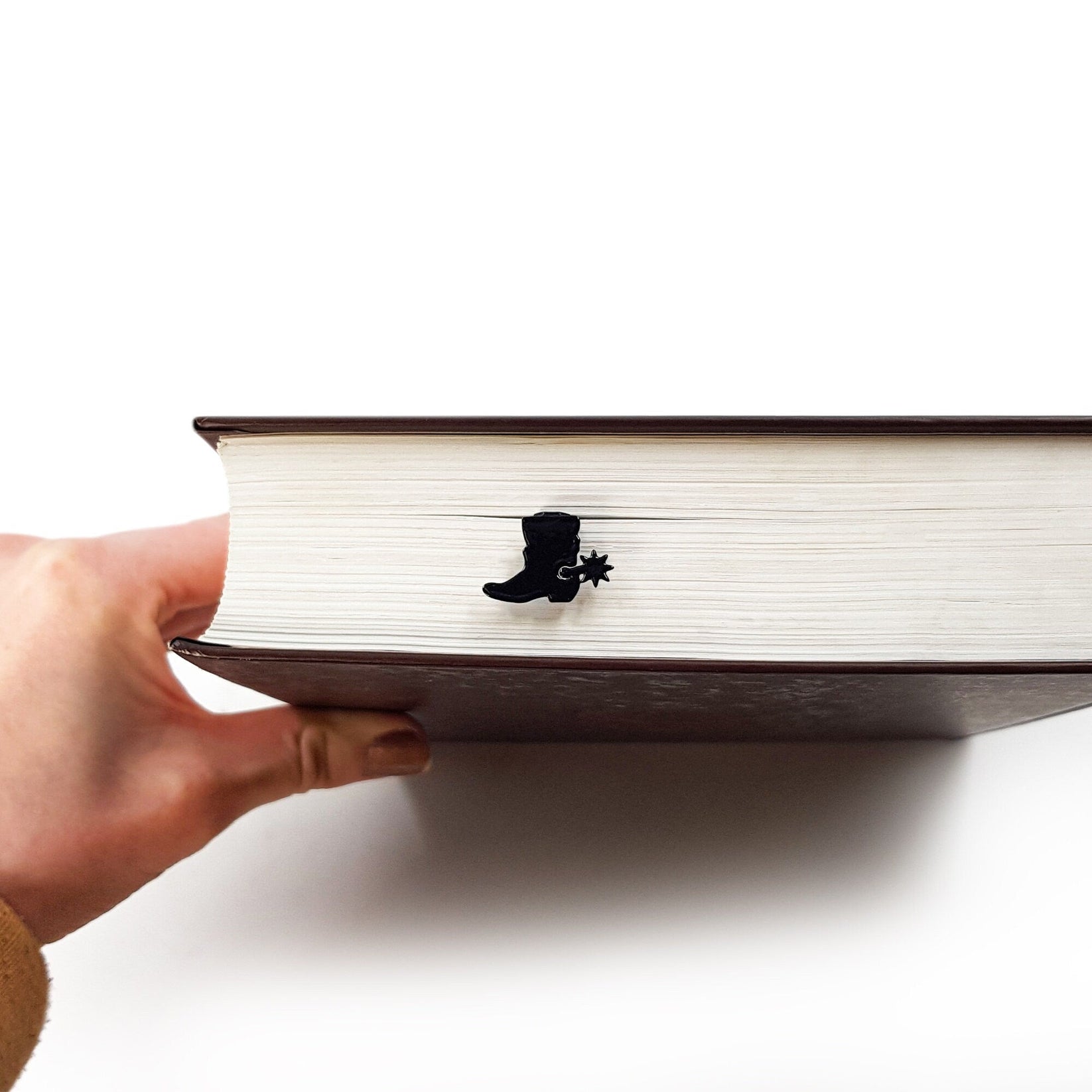 Cowboy's Boot metal bookmark seen from the edge of a closed book