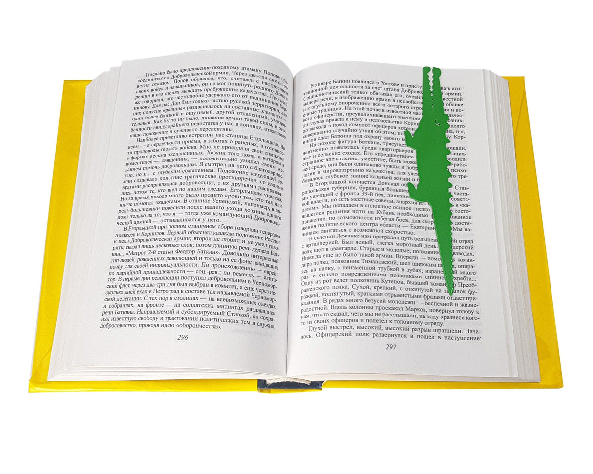 Crocodile and the Nile Bird metal bookmark in green marking a page in an open book