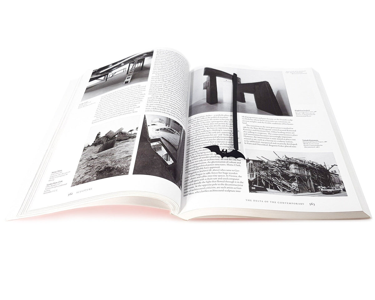 Cryptic Bat metal bookmark marking a page in an illustrated book
