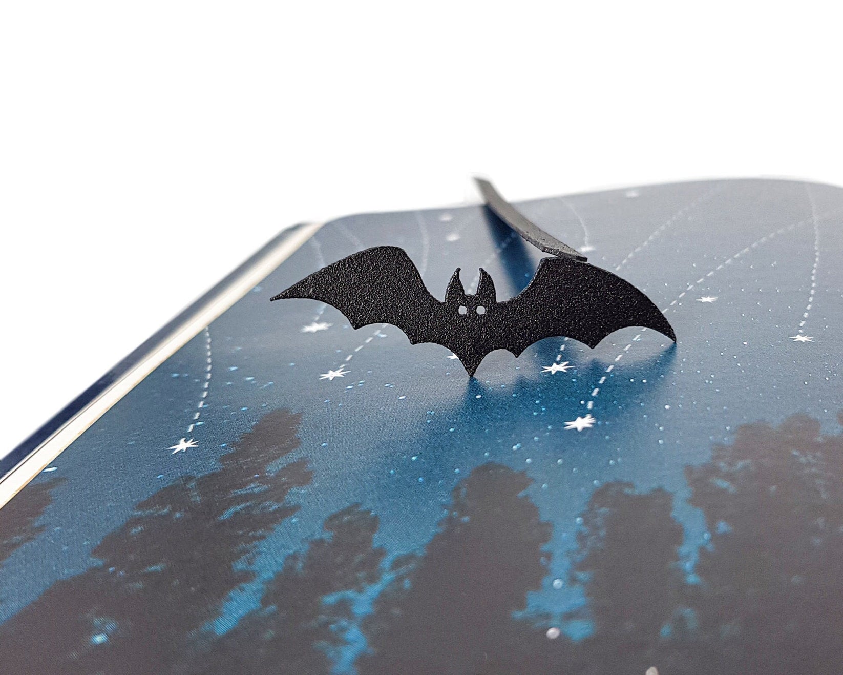 Cryptic Bat metal bookmark shot on a coloured surface