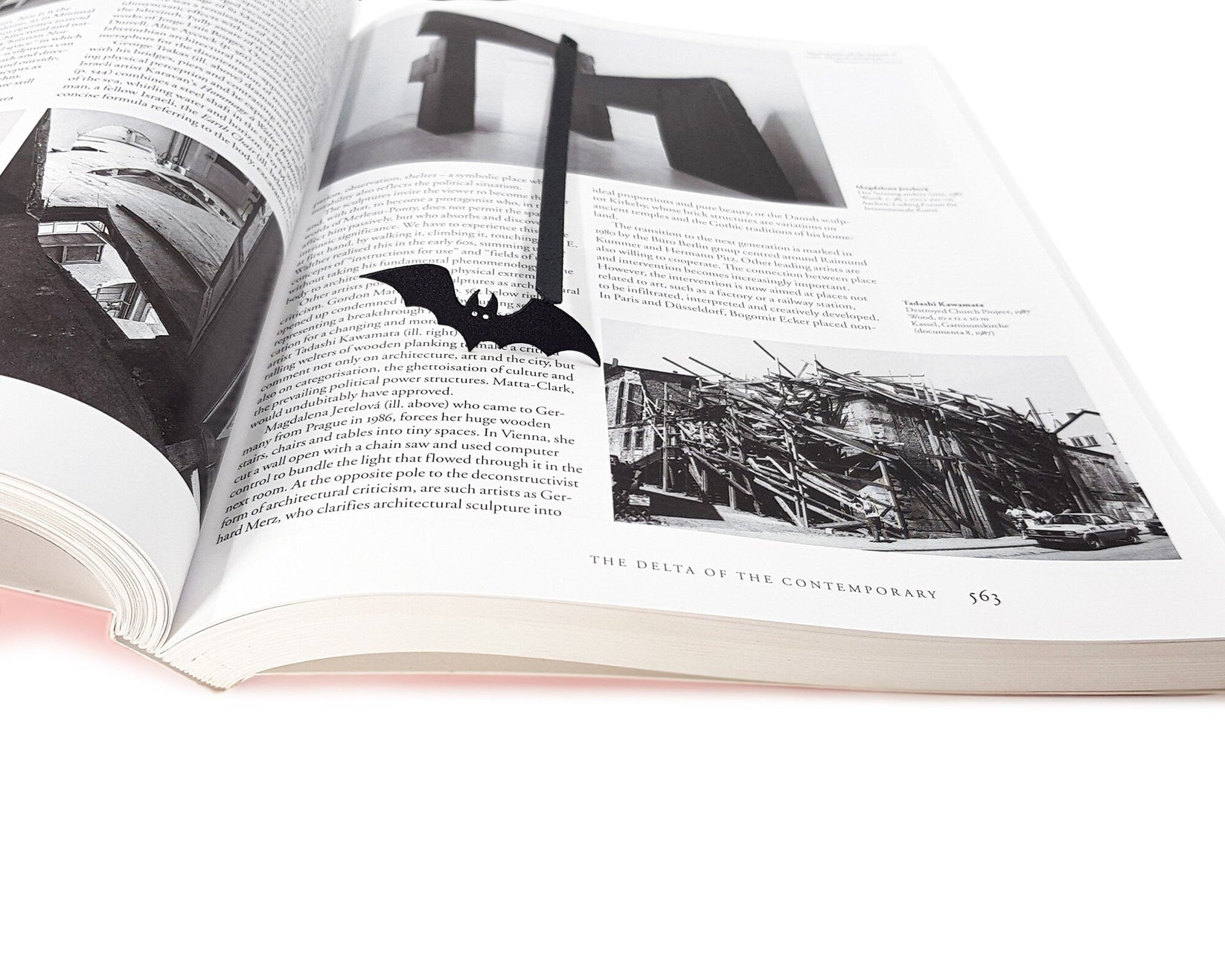 Cryptic Bat metal bookmark lying across the pages of an open book