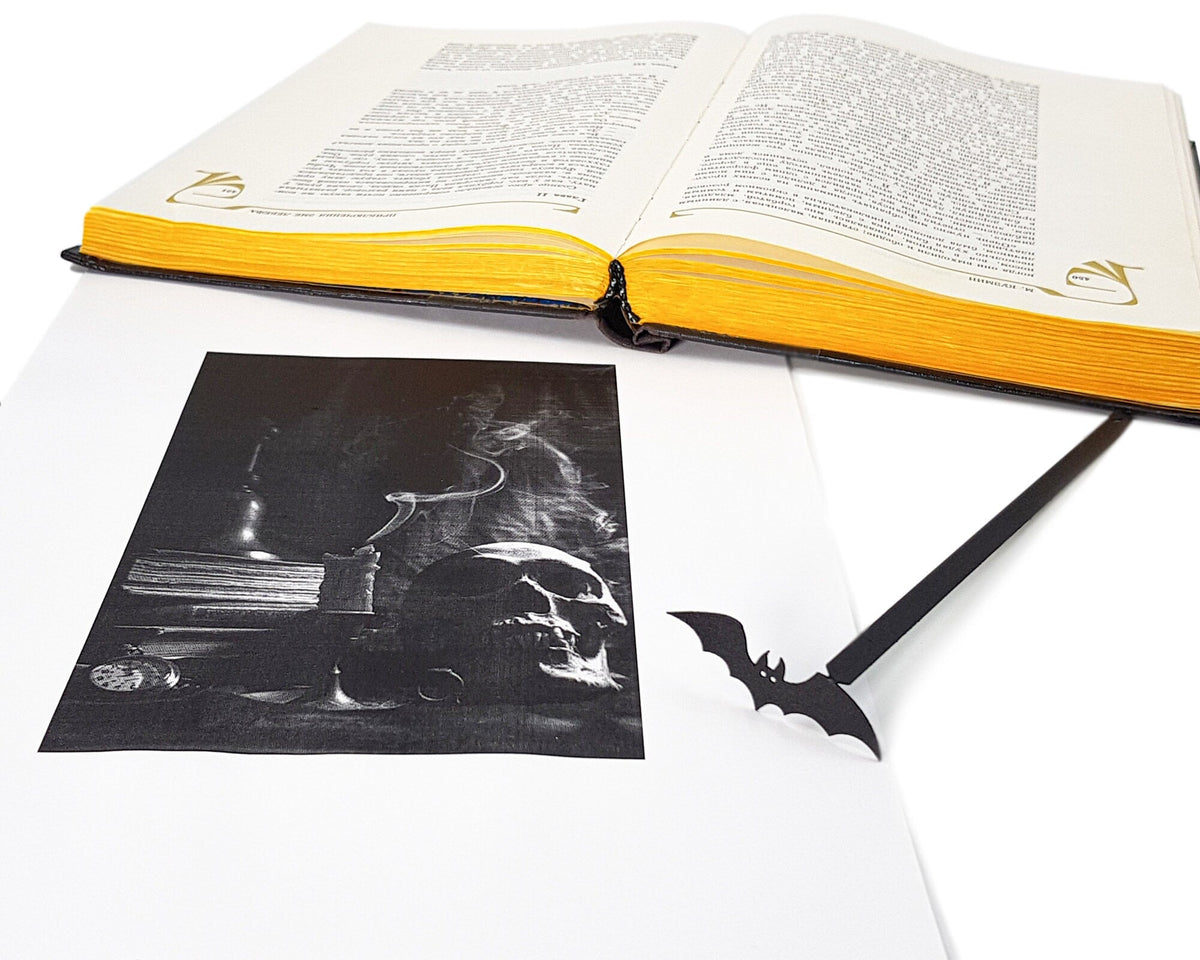 Cryptic Bat metal bookmark on an illustrated page