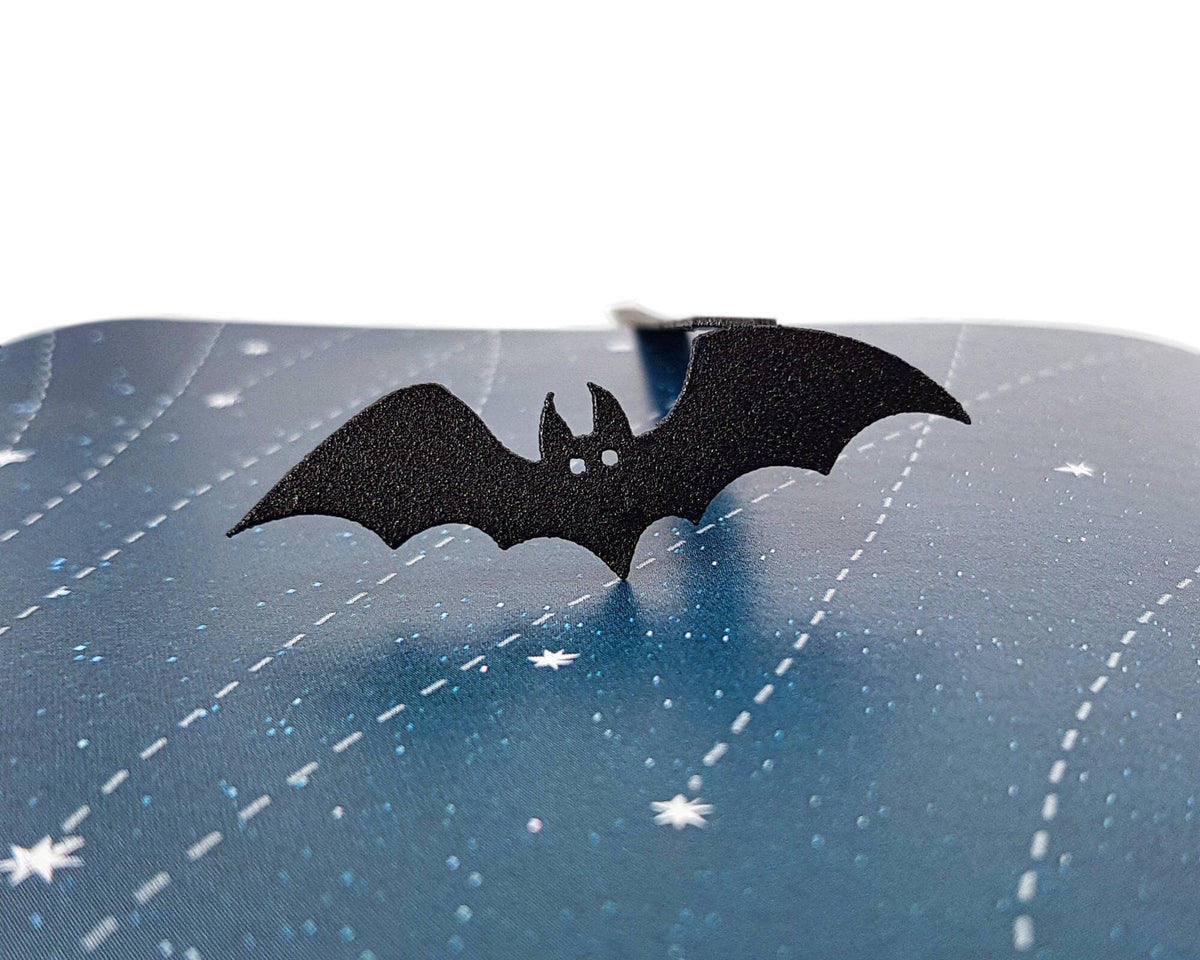 Cryptic Bat metal bookmark against a coloured backdrop