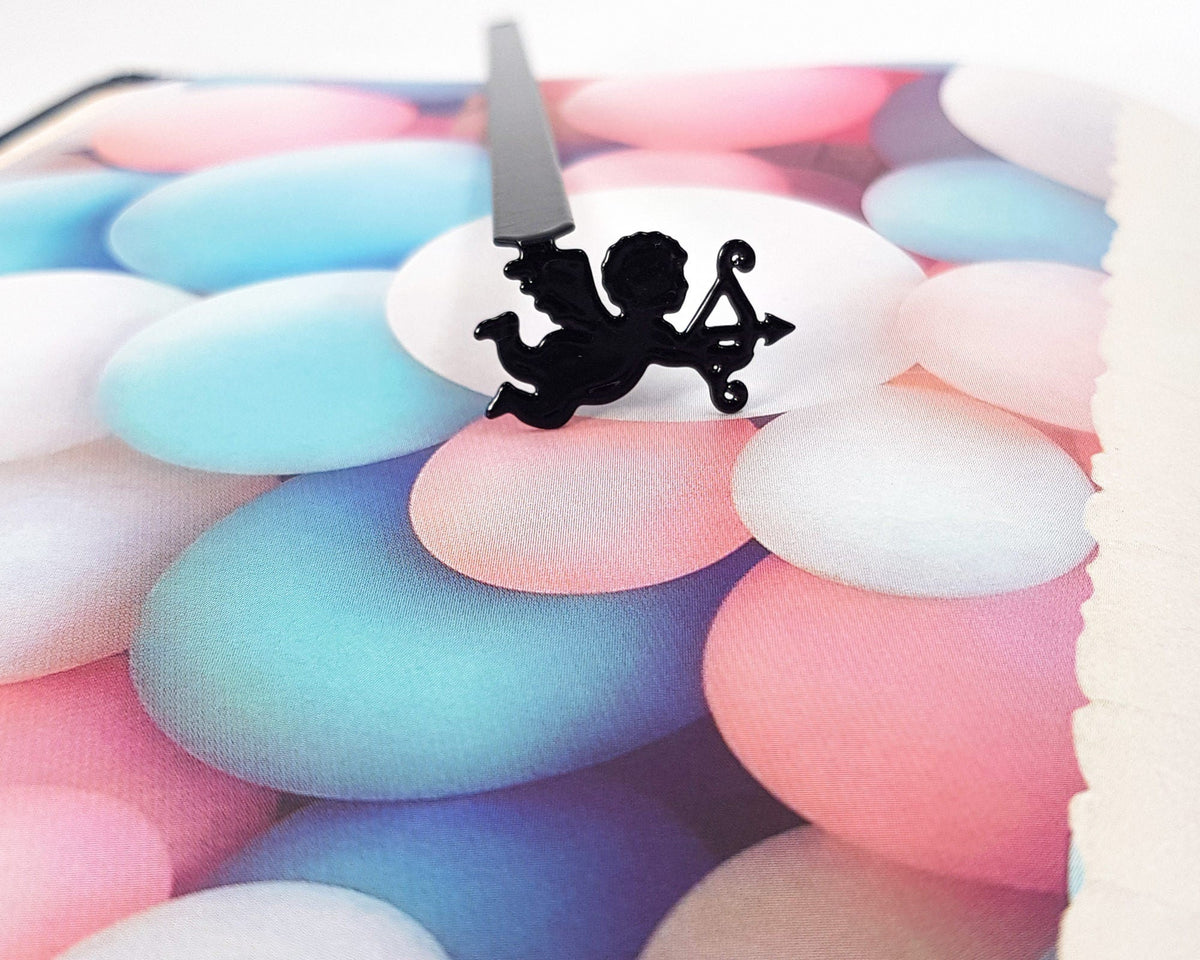 Cupid metal bookmark on a coloured background