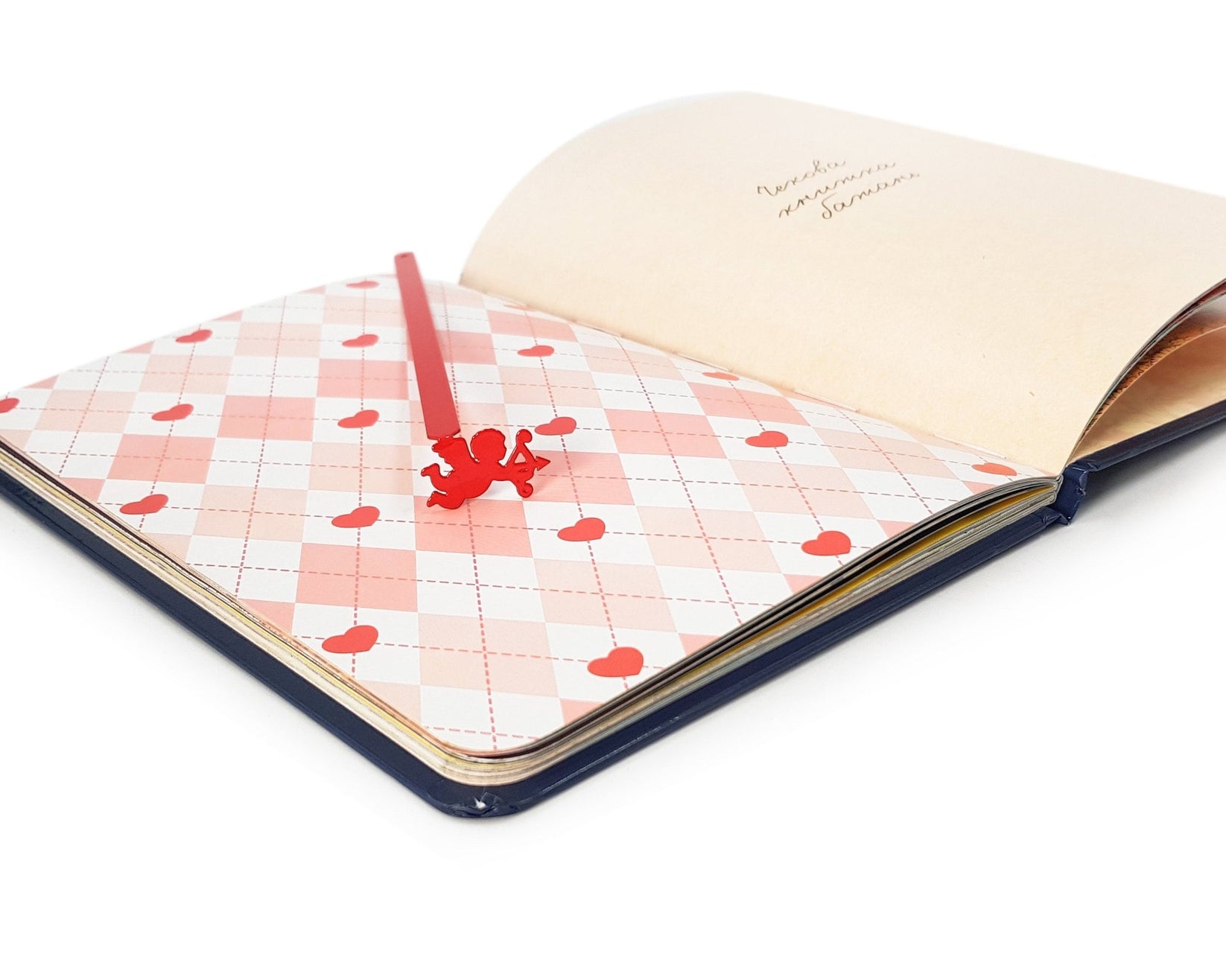 Cupid metal bookmark marking a page in a notebook