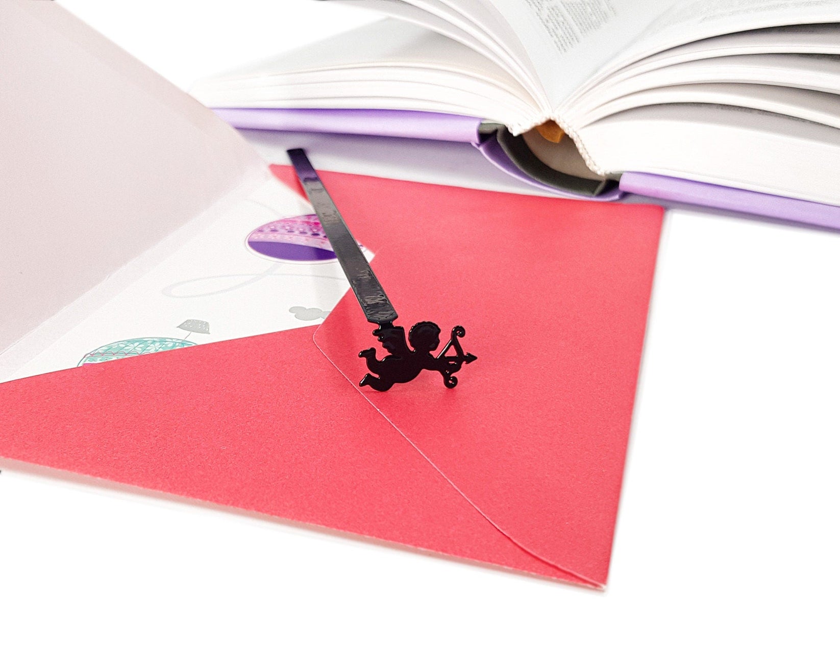 Cupid metal bookmark against a coloured backdrop