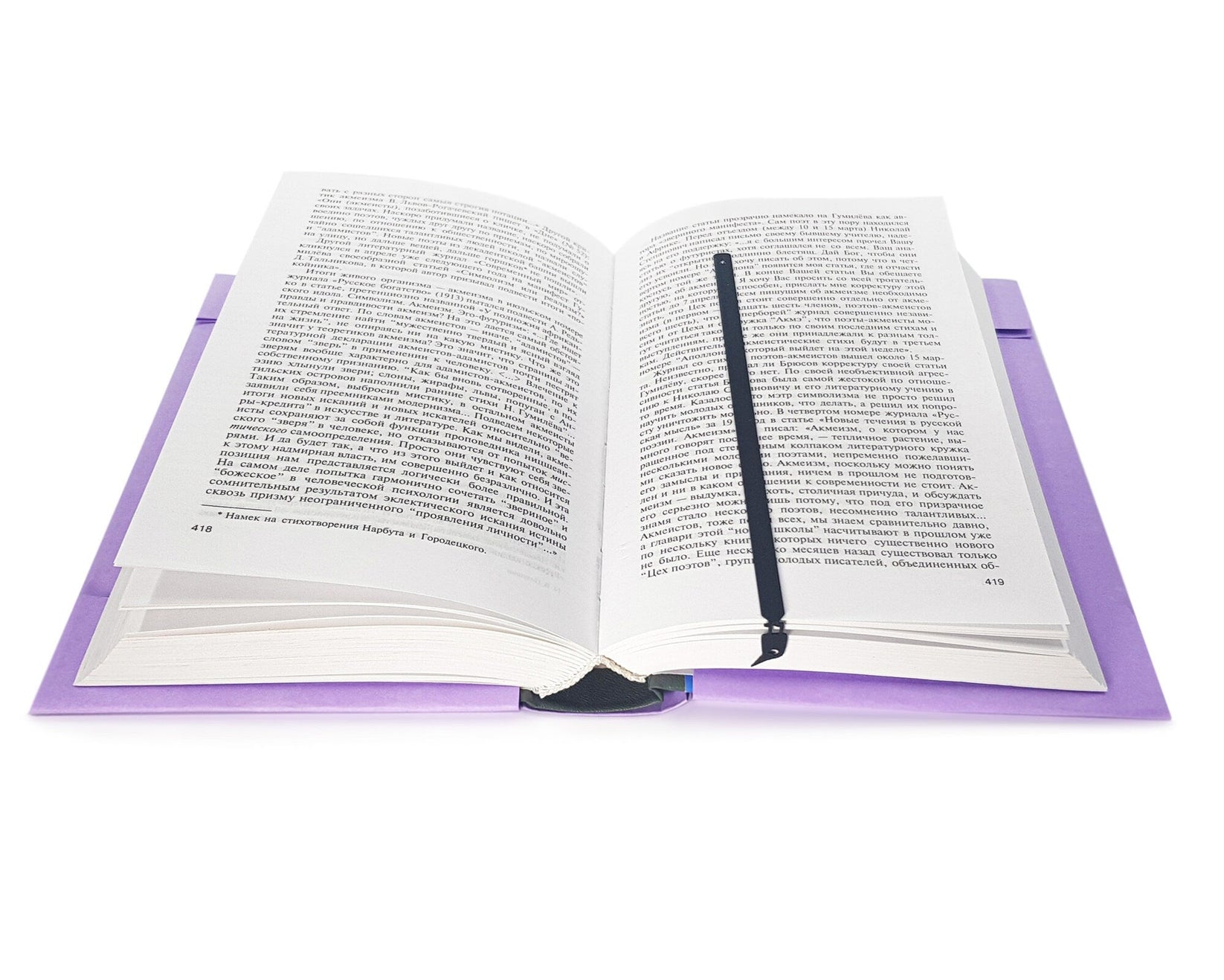 Curious Bird metal bookmark marking a page in an open book