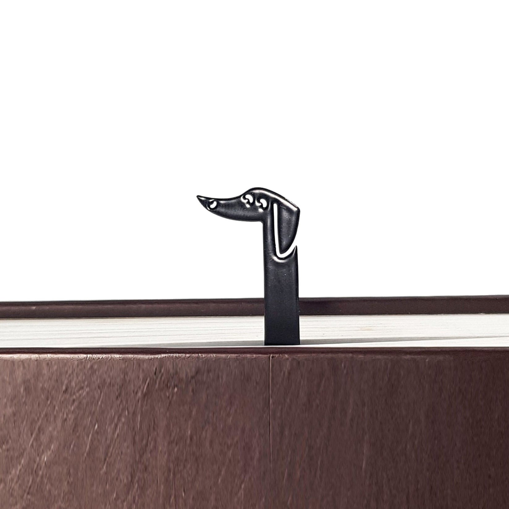 Dachshund My Long Time Friend metal bookmark in a closed book, only its top showing above the pages