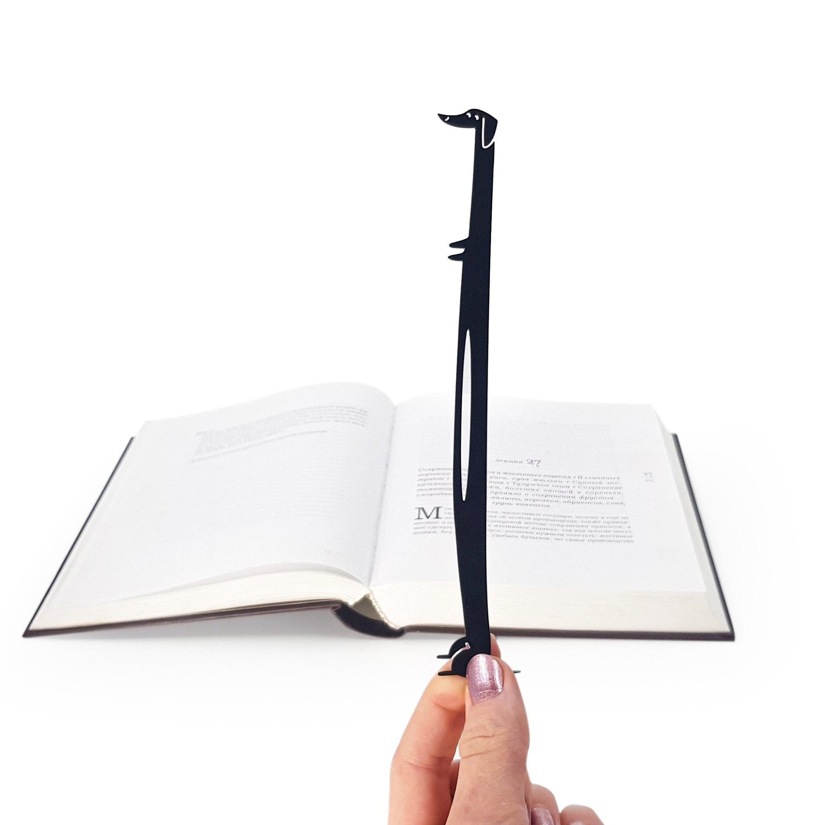 Dachshund My Long Time Friend metal bookmark held in a hand above an open book