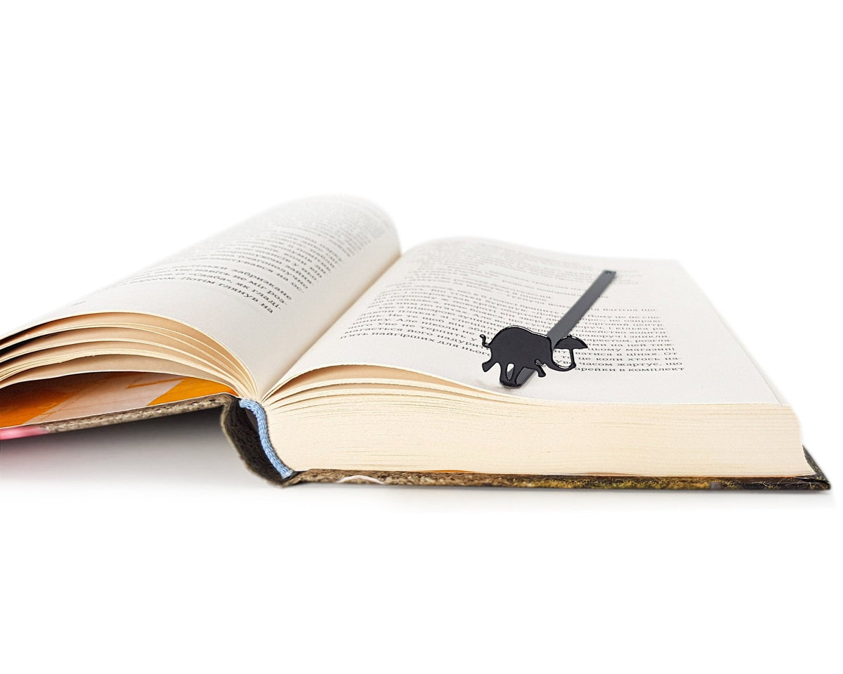Dancing Elephant metal bookmark marking a page in an open book
