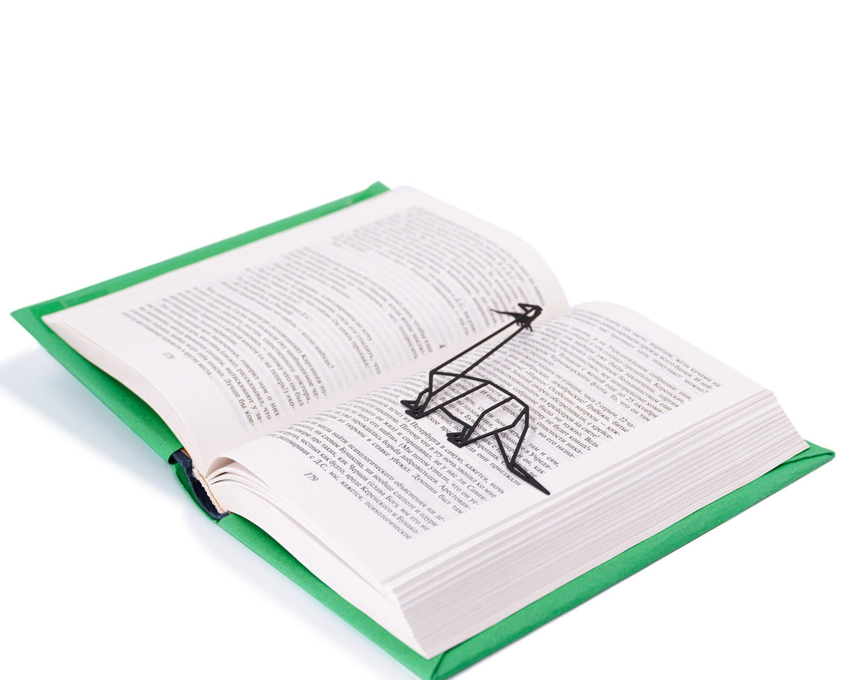 Dinosaur Geometry Style metal bookmark marking a page in an open book