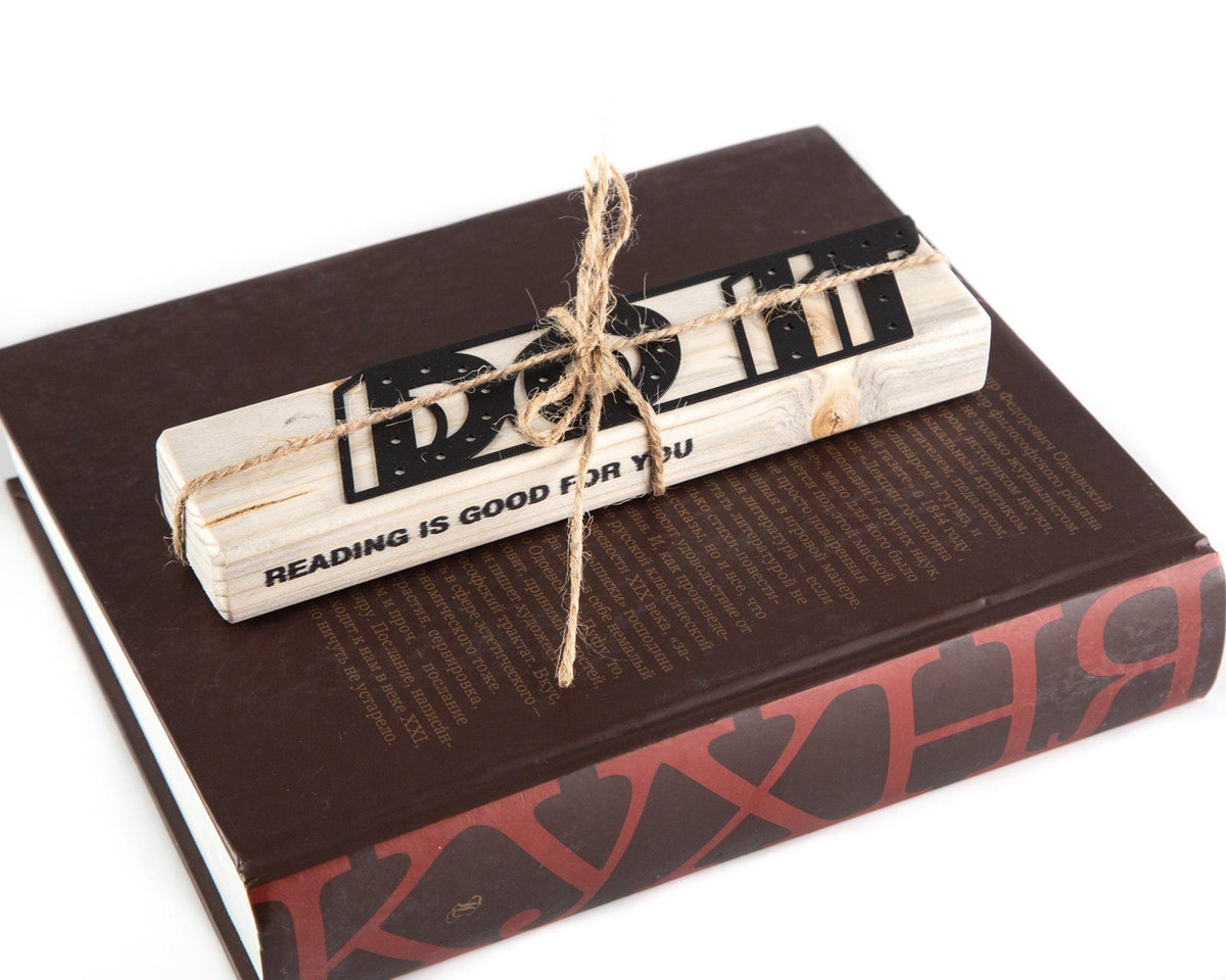 Do It metal bookmark in a closed book, only its top showing above the pages