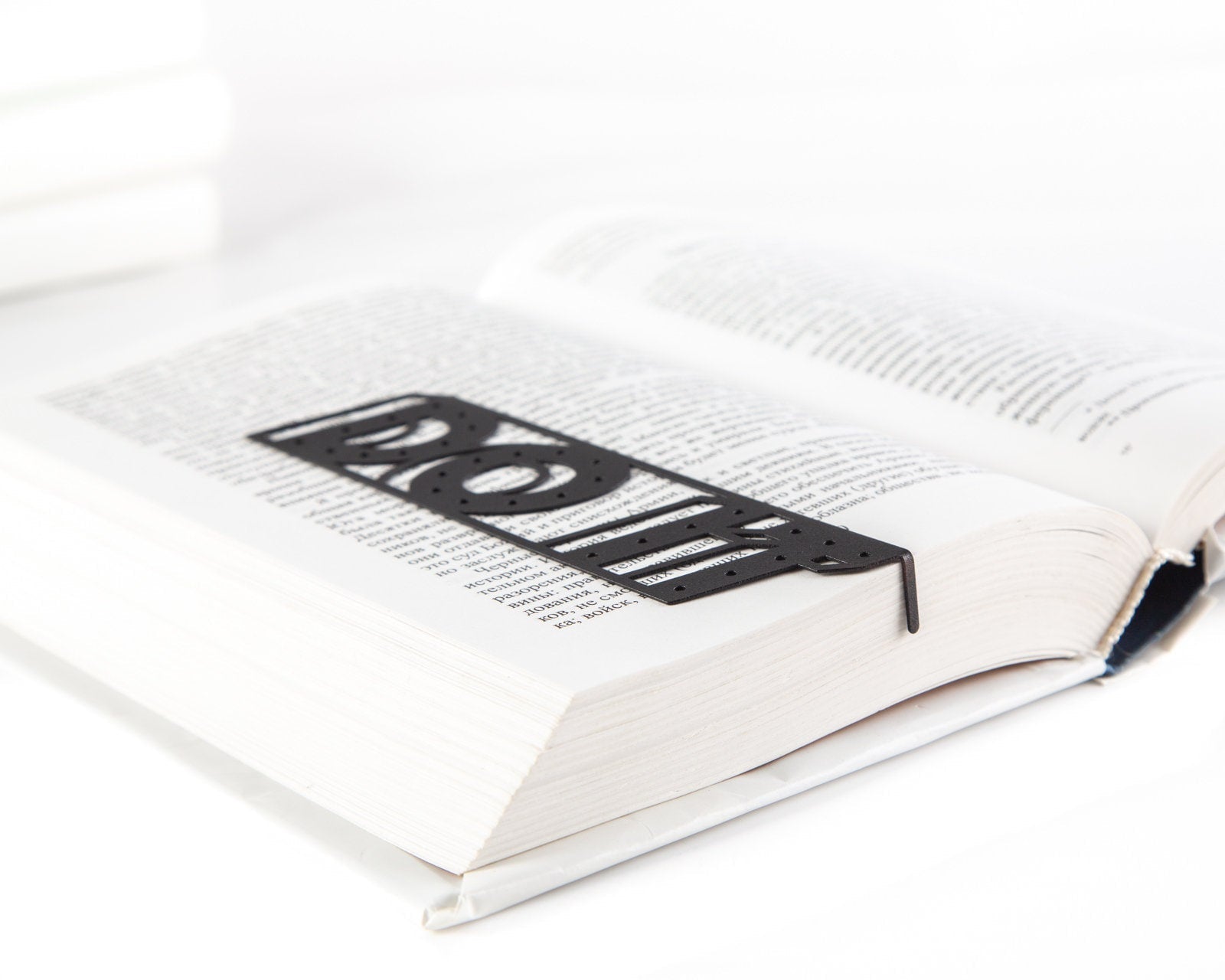 Do It metal bookmark seen from the edge of a closed book