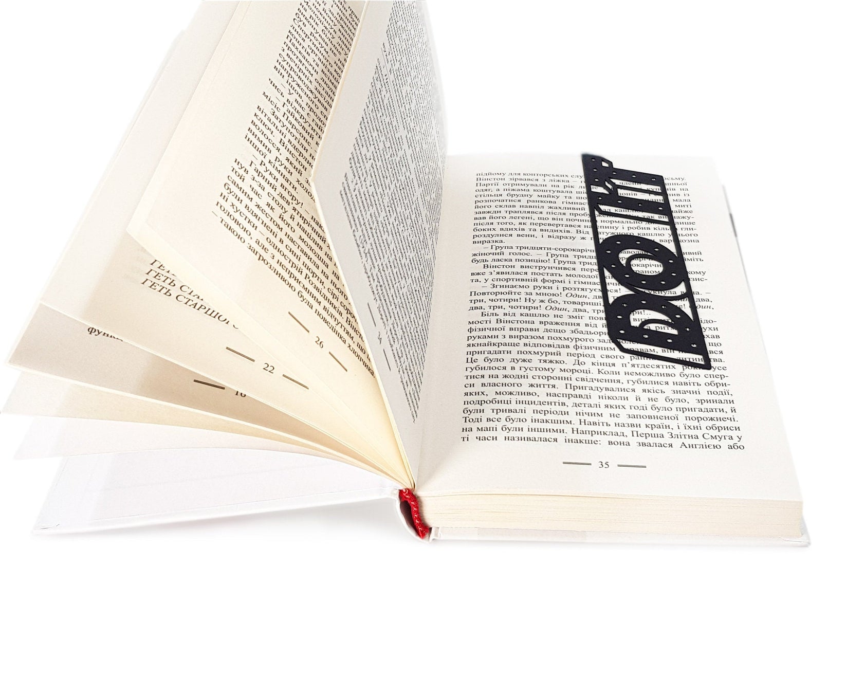 Do It metal bookmark resting on the pages of an open book