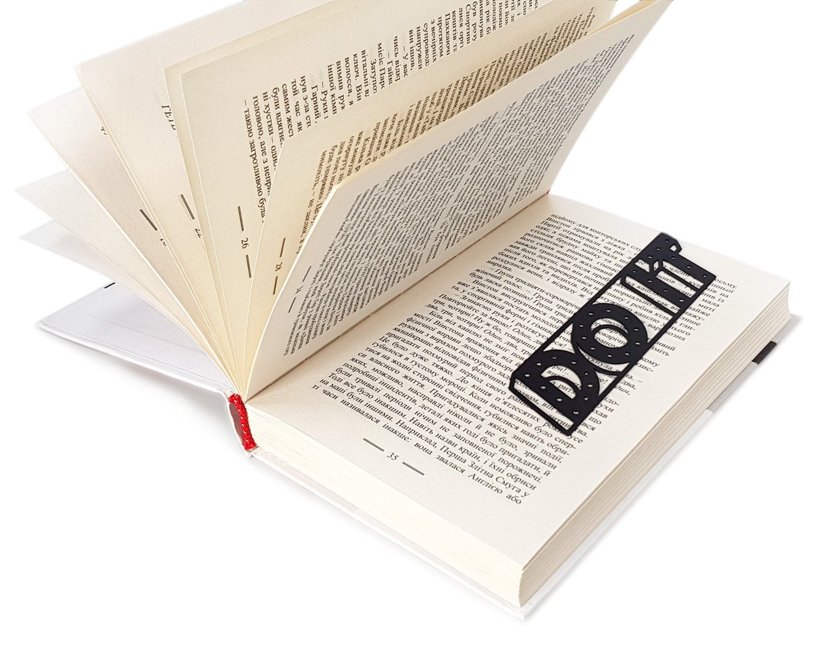 Do It metal bookmark marking a page in an open book