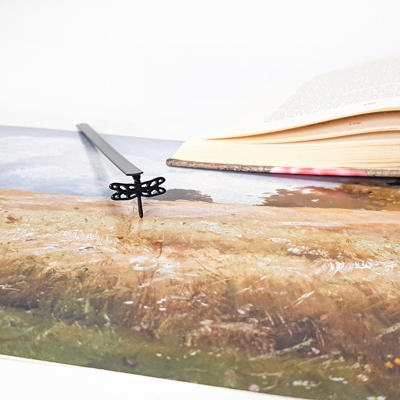 Dragonfly metal bookmark on an illustrated page