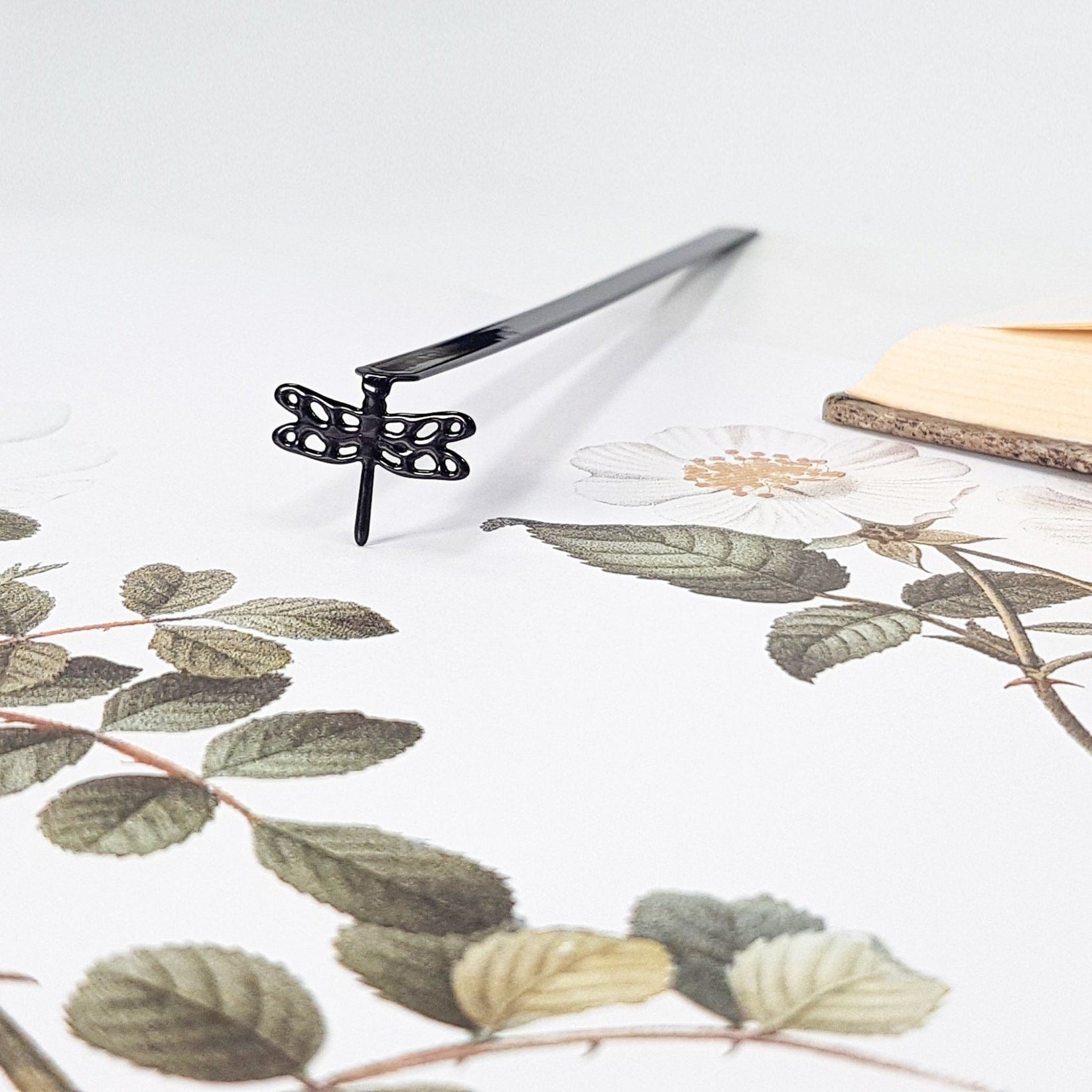 Dragonfly metal bookmark on a coloured background
