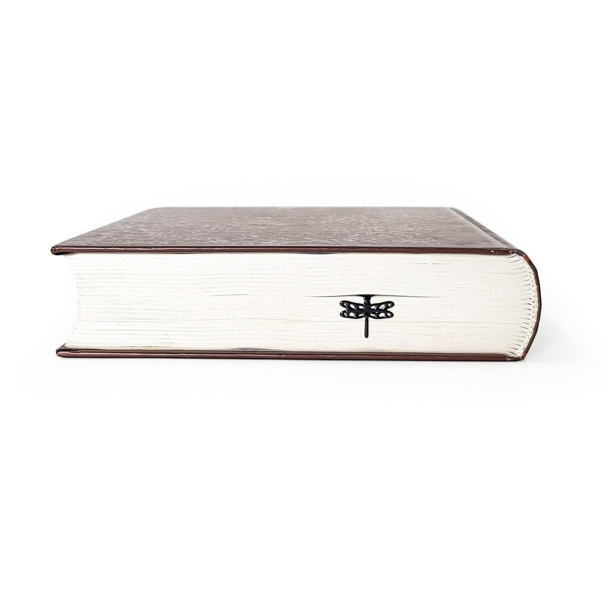 Dragonfly metal bookmark in a closed book, only its top showing above the pages