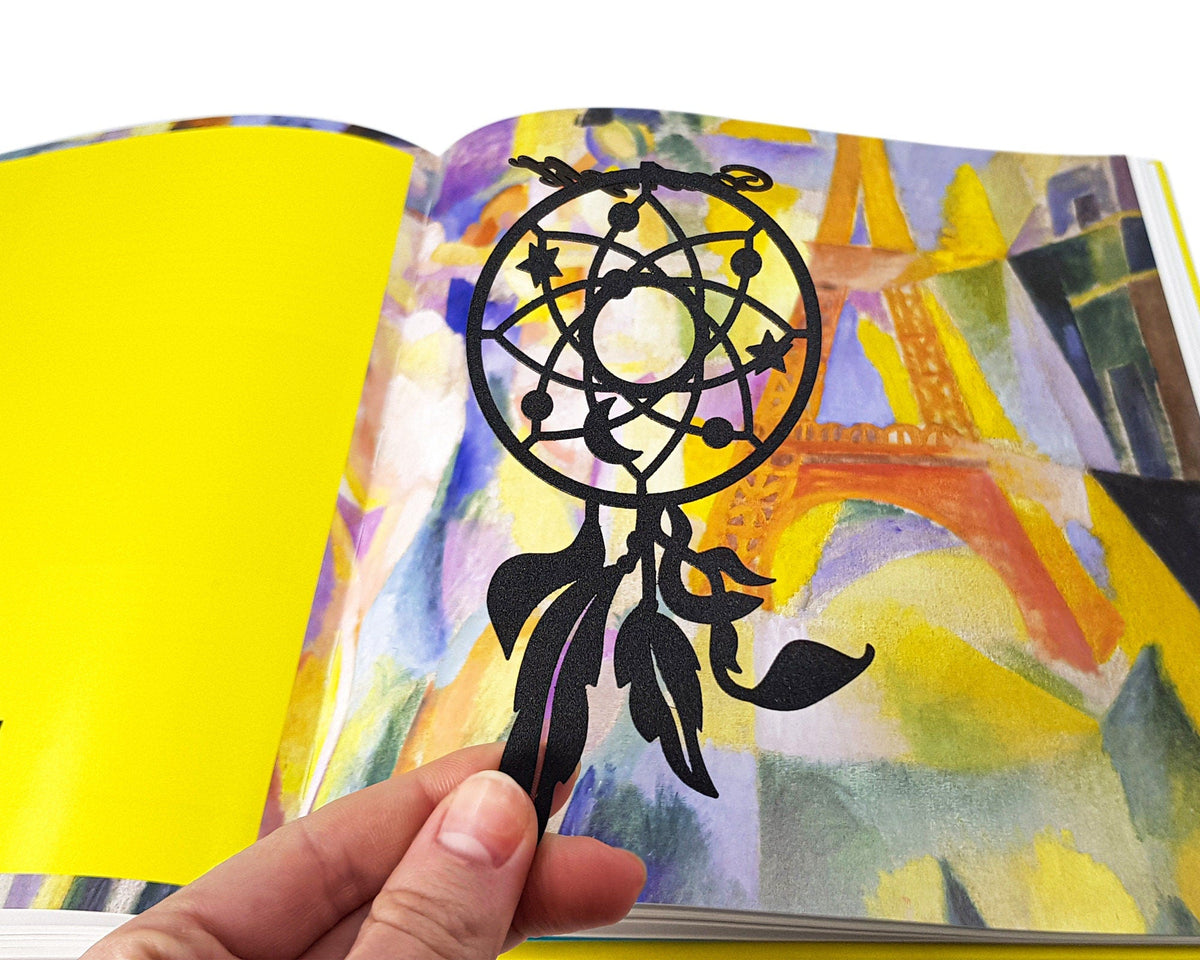 Dream Catcher metal bookmark placed on a colour illustration