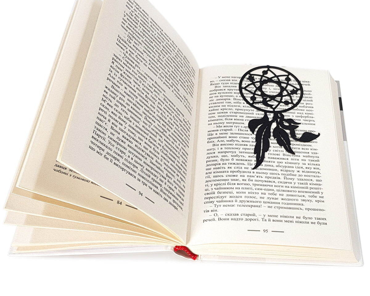 Dream Catcher metal bookmark resting on the pages of an open book