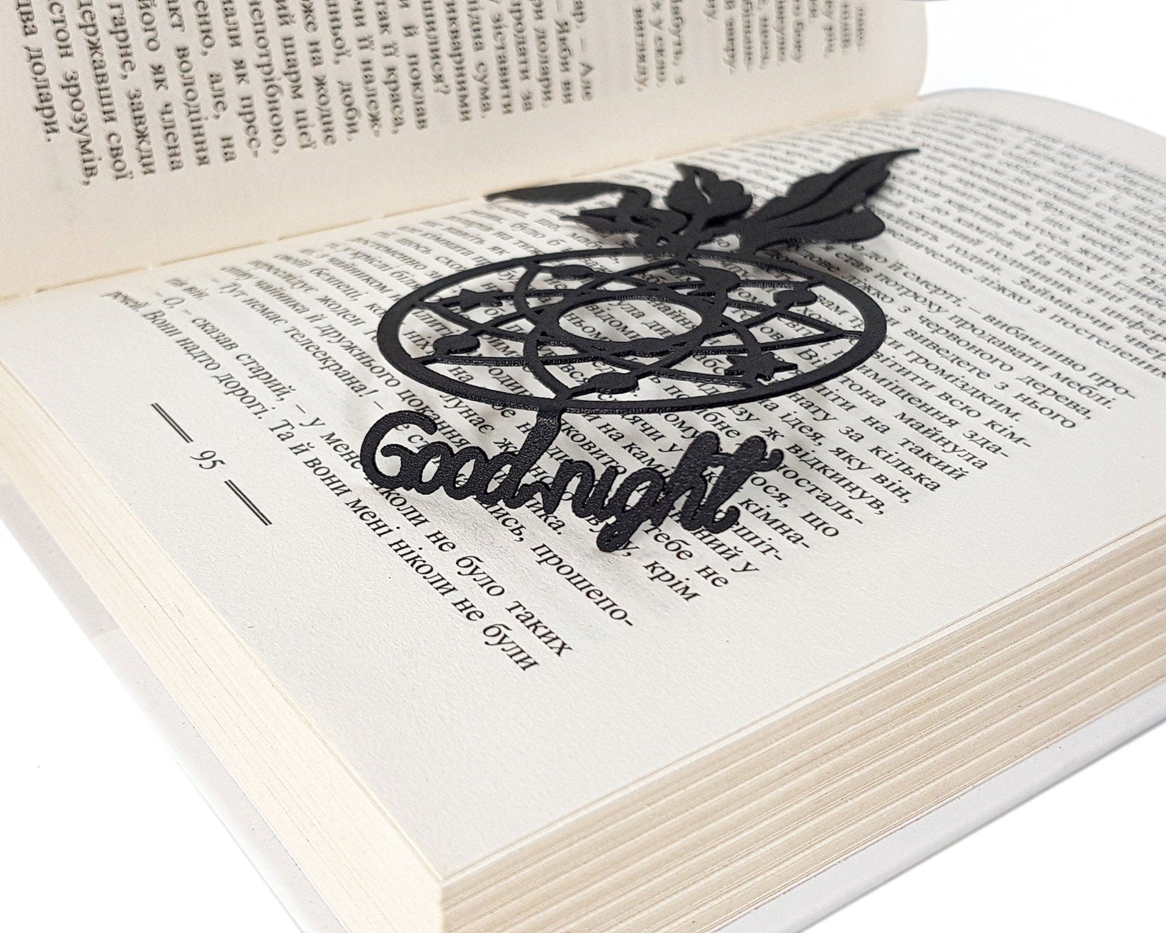 Dream Catcher metal bookmark marking a page in an open book