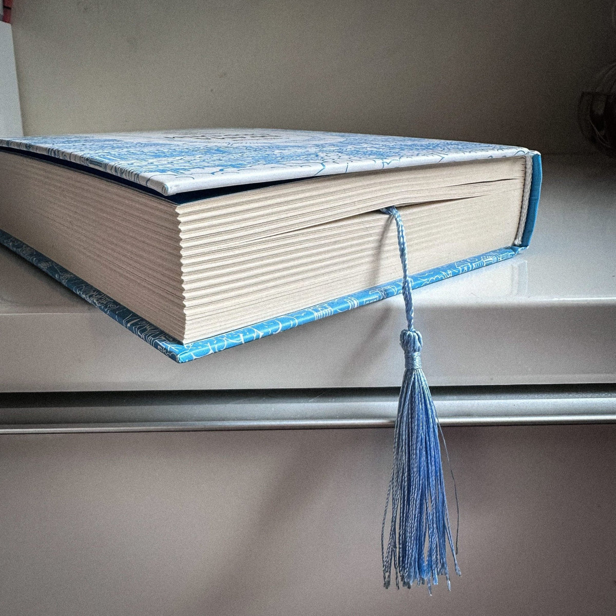 Dreamer metal bookmark in a closed book, only its top showing above the pages