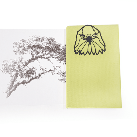 Eagle's Head metal bookmark marking a page in an illustrated book