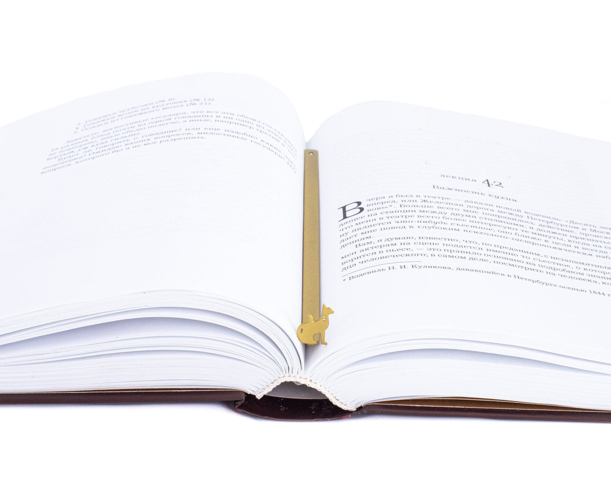Egyptian Cat metal bookmark in gold marking a page in an open book
