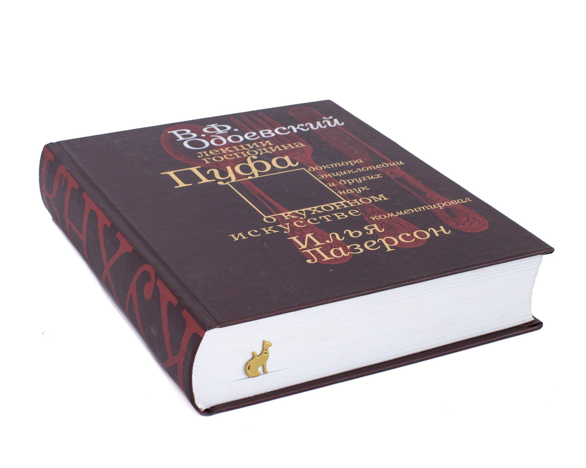 Egyptian Cat metal bookmark in gold seen from the edge of a closed book