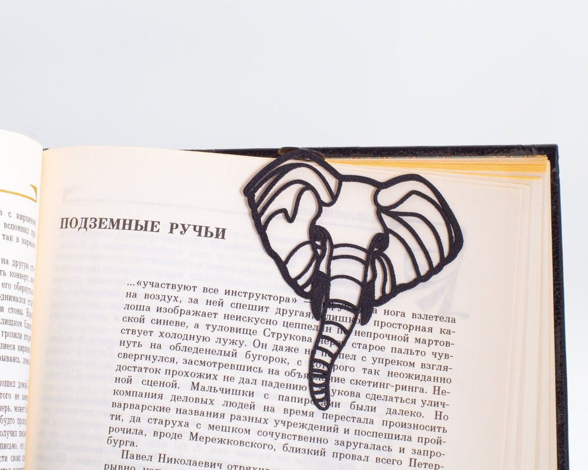 Elephant metal bookmark resting on the pages of an open book