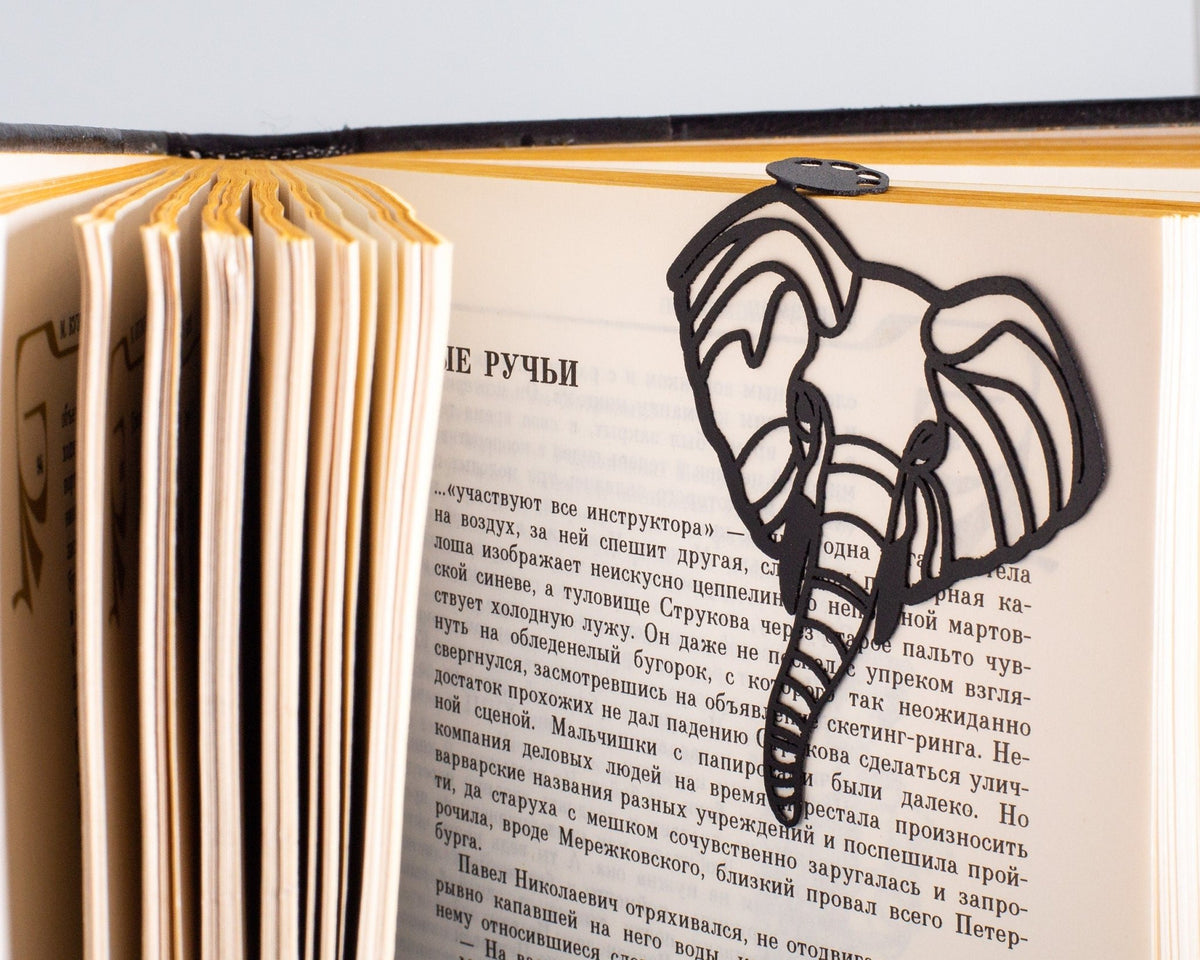 Elephant metal bookmark marking a page in an open book