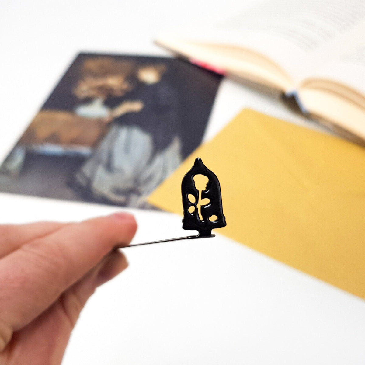 Enchanted Rose metal bookmark marking a page in an illustrated book