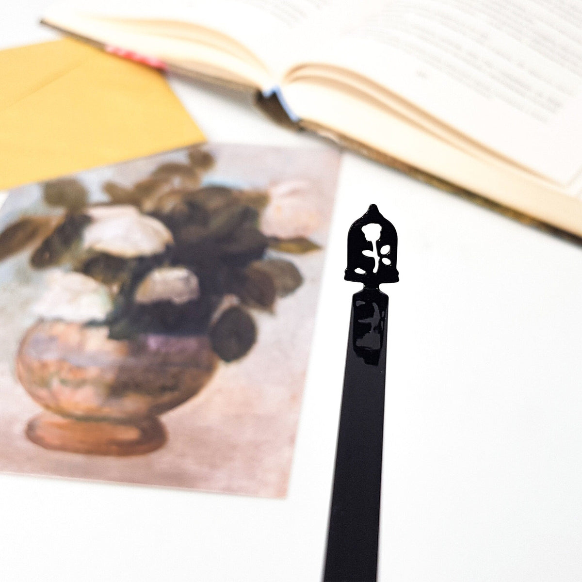 Enchanted Rose metal bookmark on an illustrated page