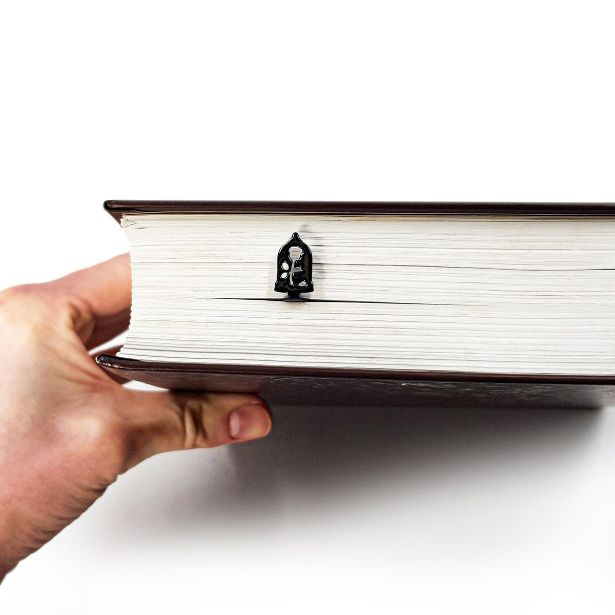 Enchanted Rose metal bookmark in a closed book, only its top showing above the pages